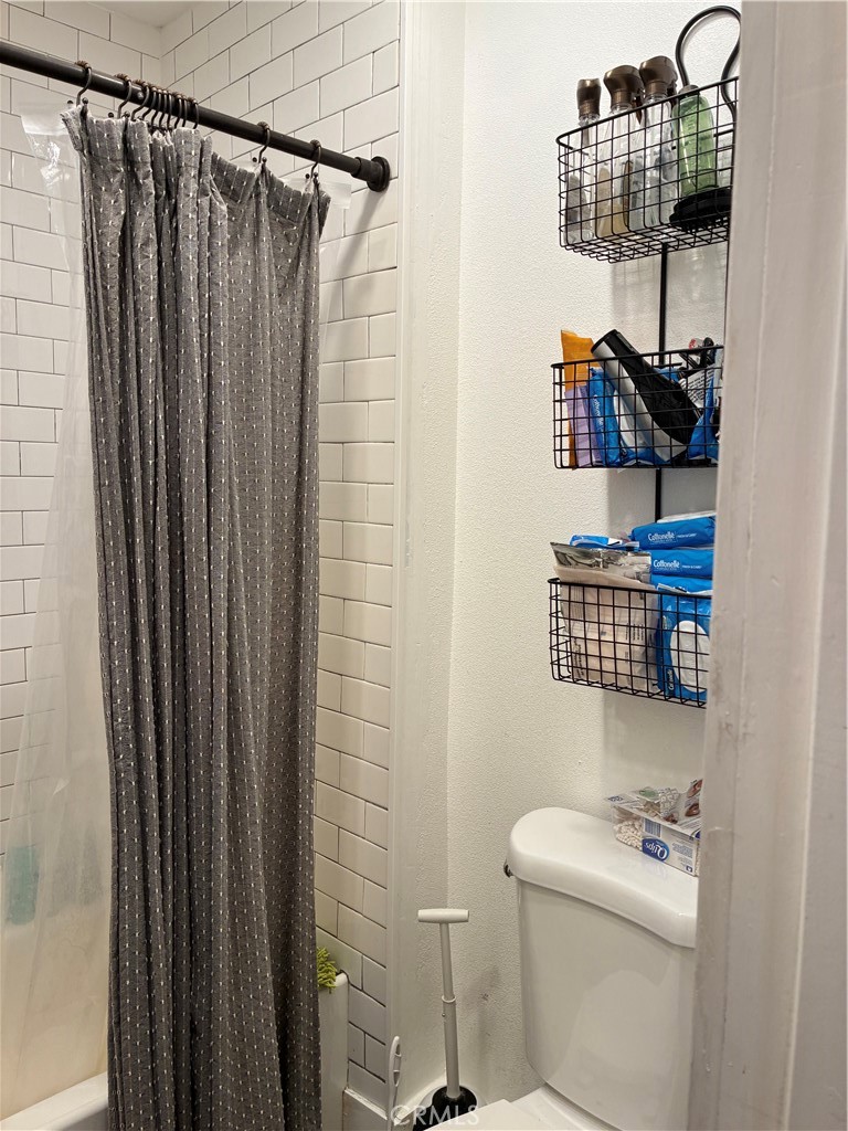 8990 19th Street, Unit 329 Rancho Cucamonga, CA 91701 - Photo 4 of 13 a bathroom with a sink a toilet and shower curtain