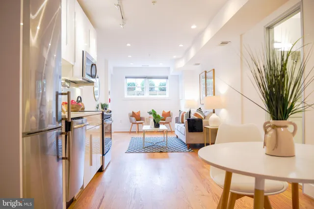 a living room with furniture a large window and wooden floor