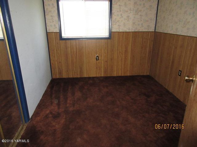 270 Evans Road Wapato, WA 98951 - Photo 12 of 42 a view of an empty room with wooden floor and a window