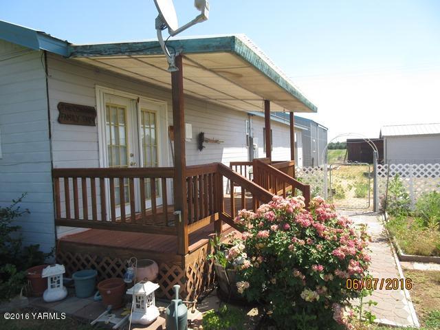 270 Evans Road Wapato, WA 98951 - Photo 5 of 42 a view of a house with a small yard and flower plants