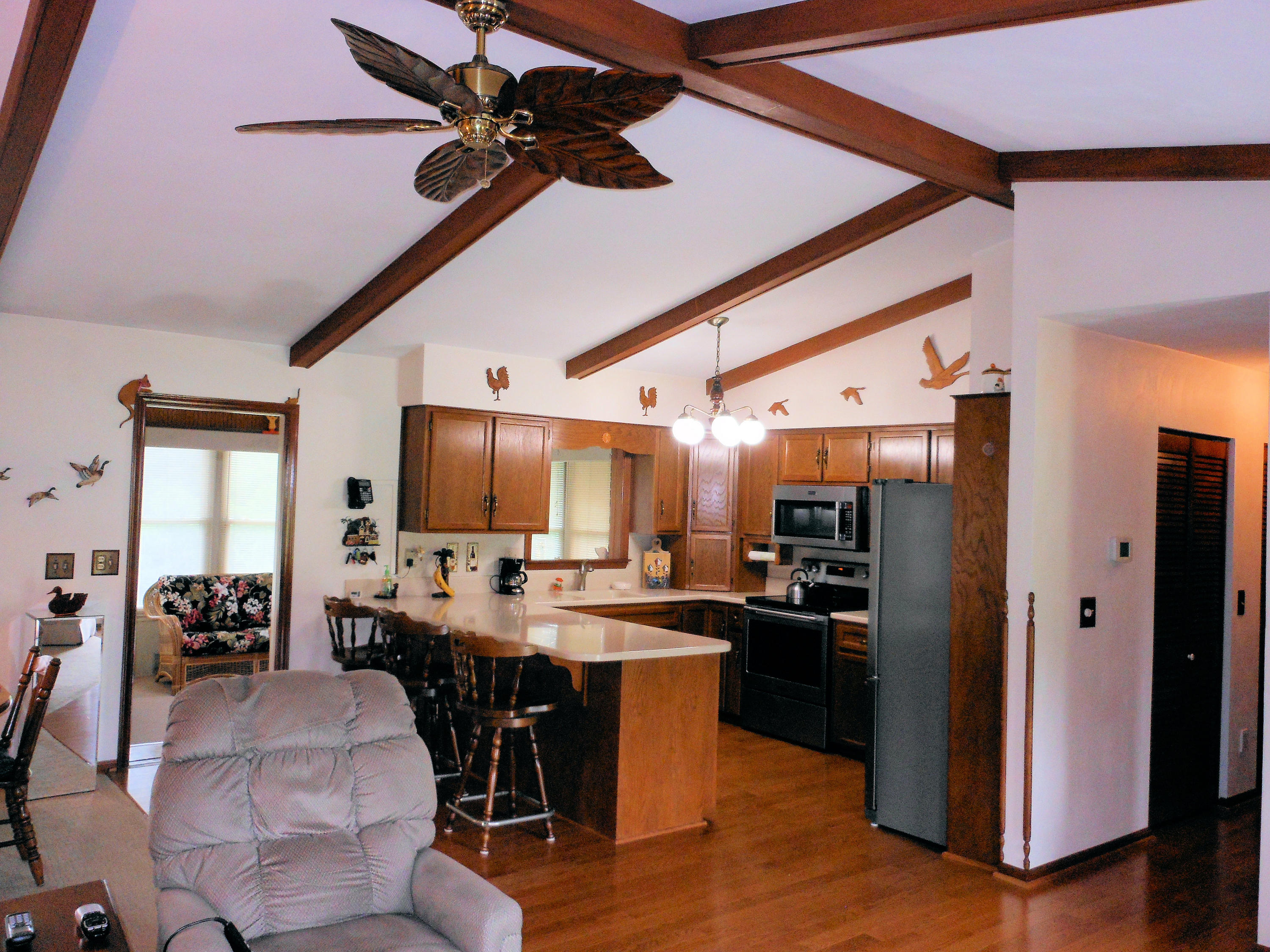 2767 Rutrough Road Southeast Roanoke, VA 24014 - Photo 5 of 36 a kitchen with stainless steel appliances kitchen island granite countertop a refrigerator a stove a sink a dining table and chairs with wooden floor