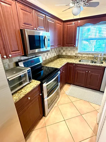 a kitchen with granite countertop a stove and a microwave