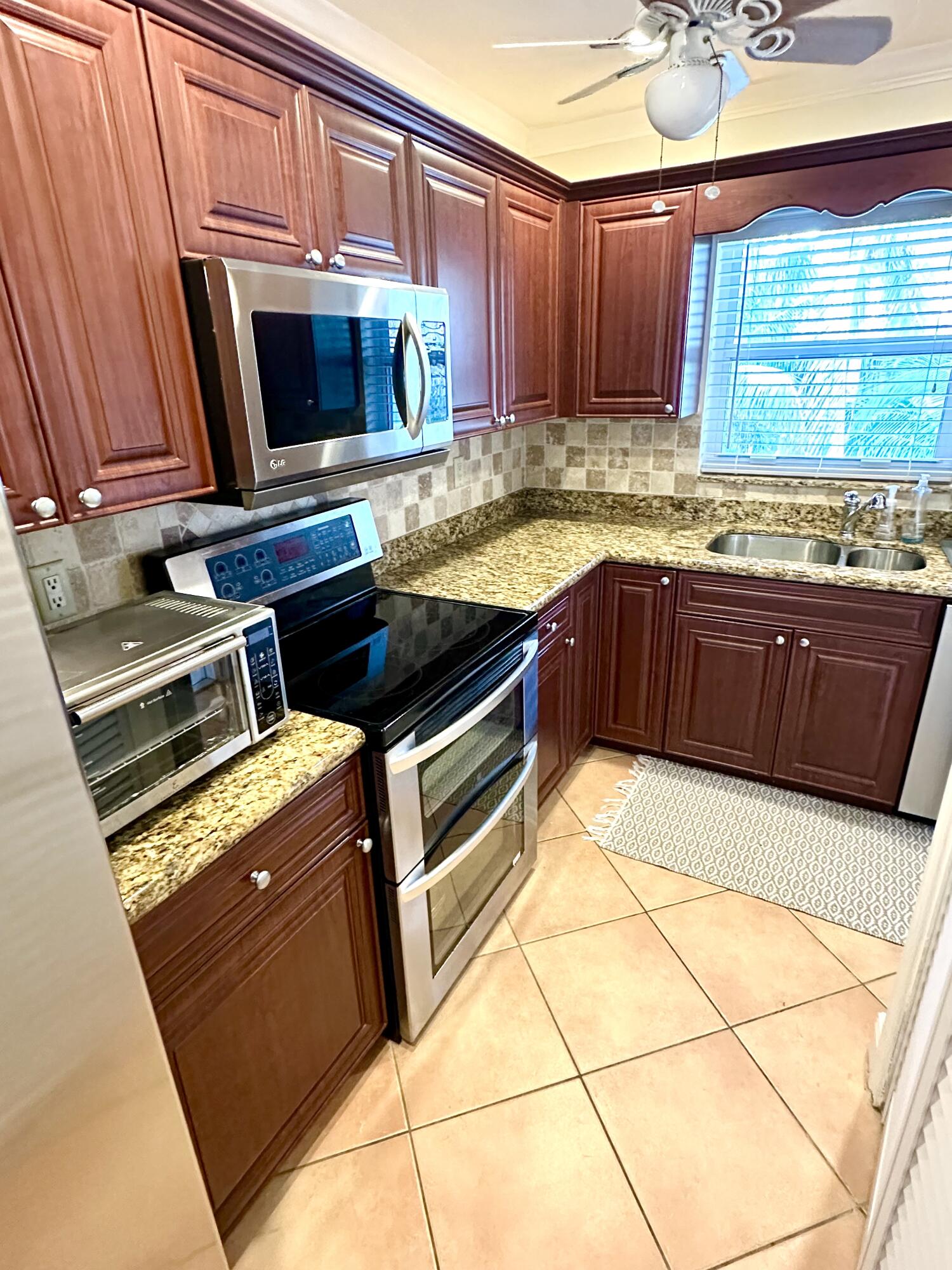 2501 South Ocean Boulevard, Unit 3040 Boca Raton, FL 33432 - Photo 6 of 22 a kitchen with granite countertop a stove and a microwave