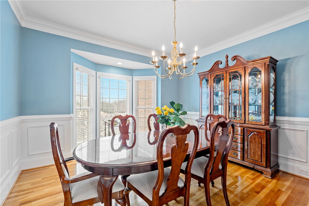 100 Farm Terrace Court Easley, SC 29642 - Photo 11 of 47 Elegant dining space perfect for entertaining, featuring lustrous hardwood flooring and intricate crown molding.