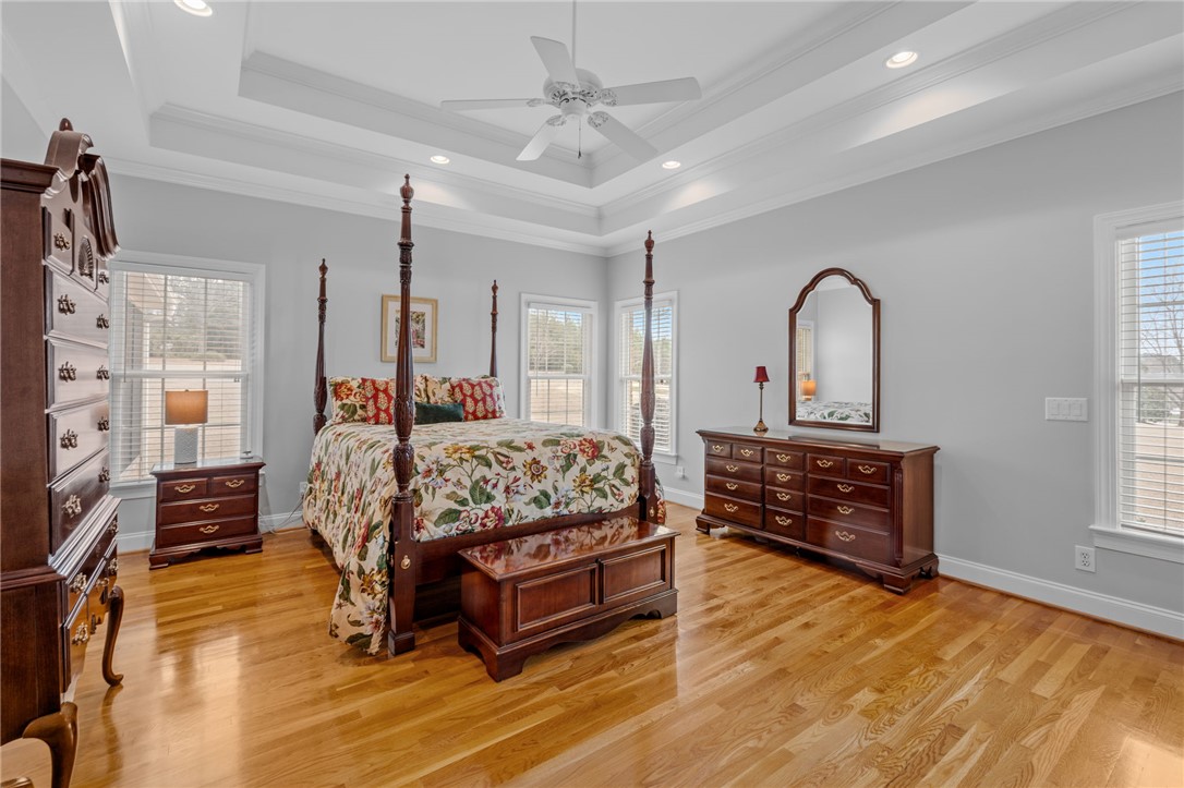 100 Farm Terrace Court Easley, SC 29642 - Photo 4 of 47 This spacious bedroom features lustrous hardwood flooring and an elegant tray ceiling with recessed lighting.