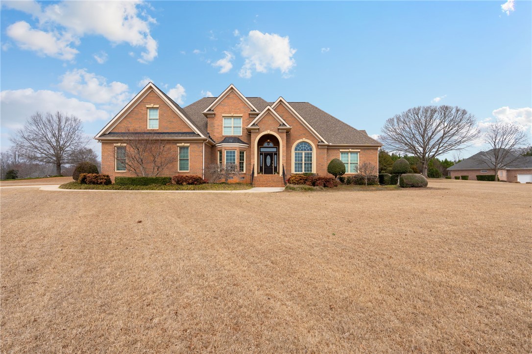 100 Farm Terrace Court Easley, SC 29642 - Photo 7 of 47 This classic brick residence features an inviting arched entryway, prominent gables, and elegant windows.