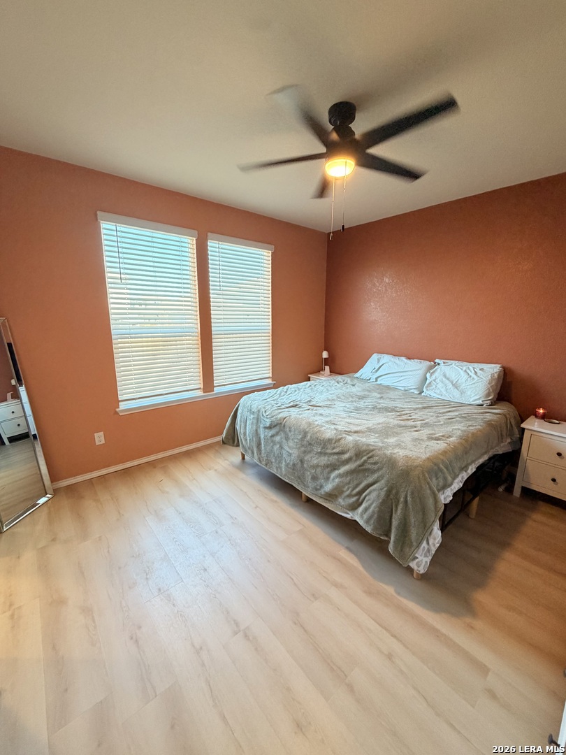 10255 Crossbuck Converse, TX 78109 - Photo 8 of 19 a bedroom with a large bed and a ceiling fan