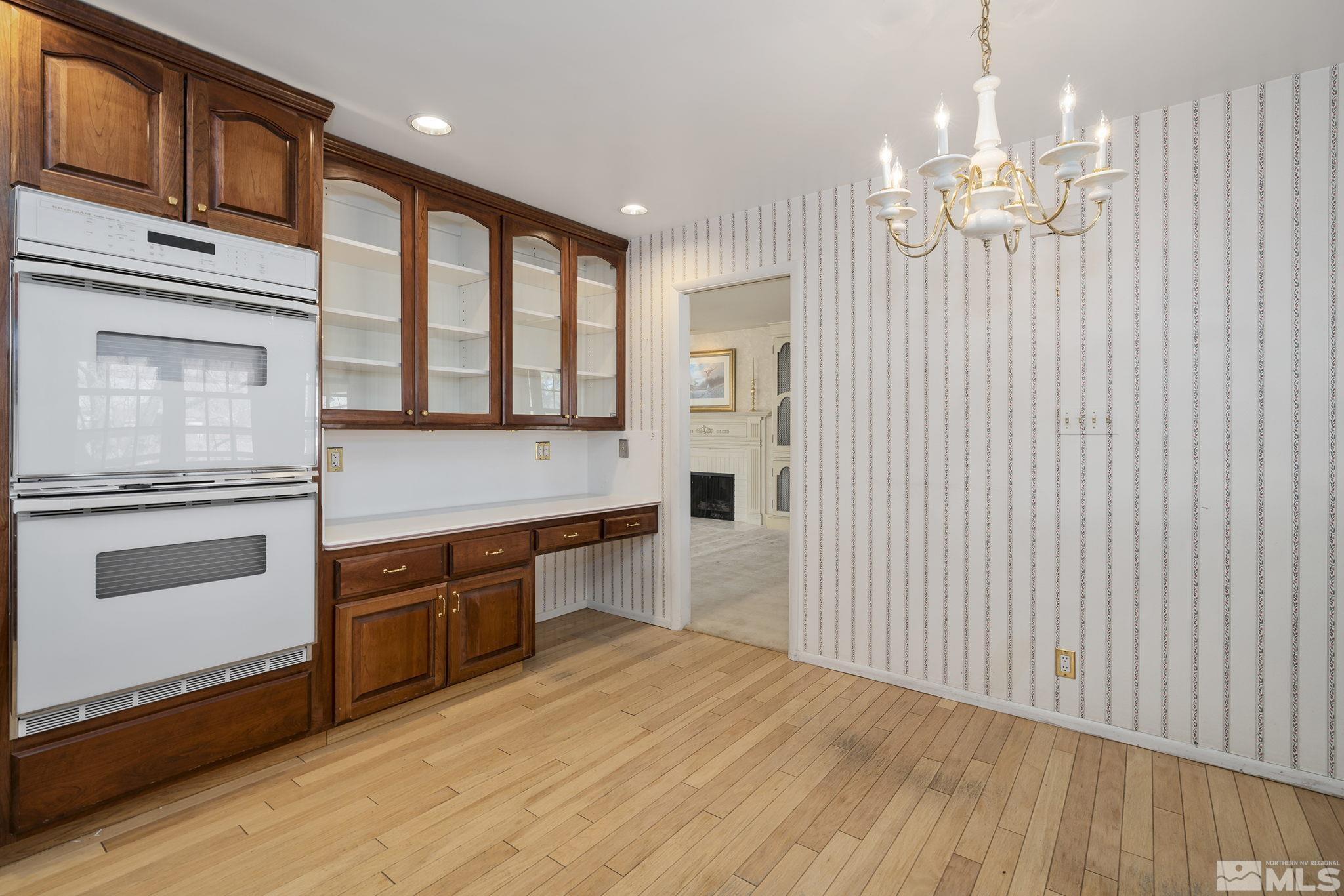 1545 Meadowview Lane Reno, NV 89509 - Photo 12 of 36 a large kitchen with granite countertop a stove top oven a sink dishwasher and white cabinets with wooden floor