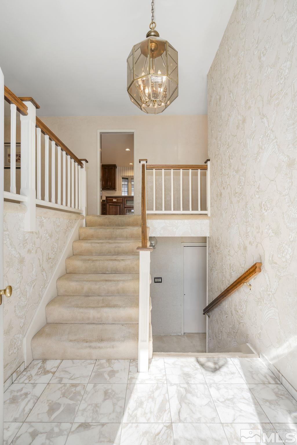 1545 Meadowview Lane Reno, NV 89509 - Photo 4 of 36 a view of a hallway with wooden floor and a chandelier