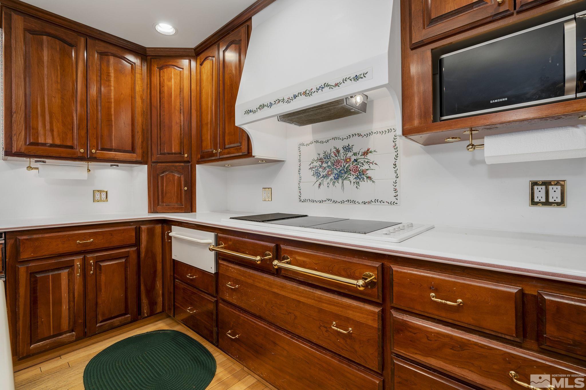 1545 Meadowview Lane Reno, NV 89509 - Photo 10 of 36 a kitchen with granite countertop wooden cabinets and a stove top oven