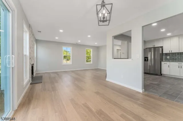 an empty room with windows and fireplace