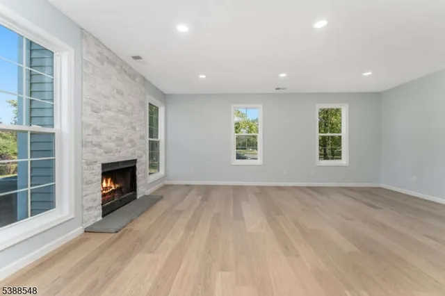 a view of empty room with wooden floor and fireplace