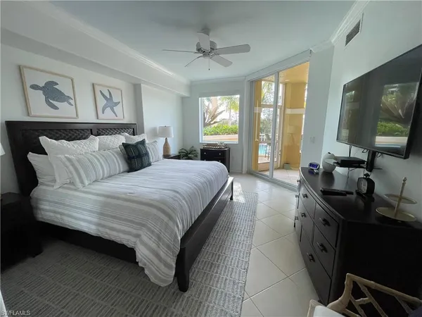 a spacious bedroom with a large bed and a flat tv screen on dresser