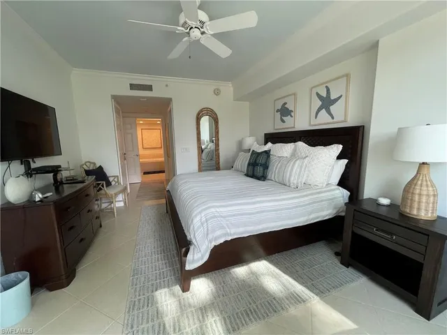 a spacious bedroom with a bed and a flat screen tv