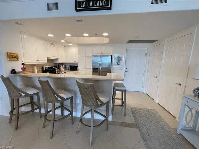 a dining area with stainless steel appliances a dining table chairs and kitchen view