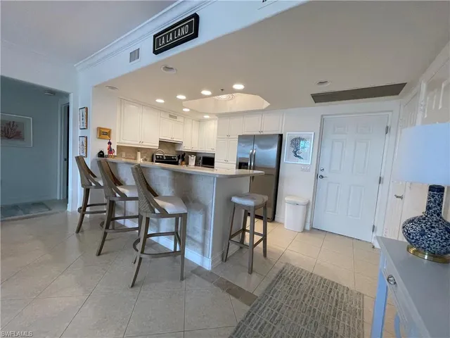 a dining room with furniture and kitchen view