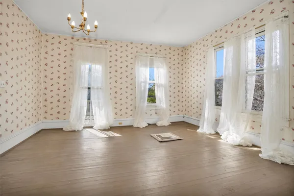 a view of an empty room with a window and a fireplace