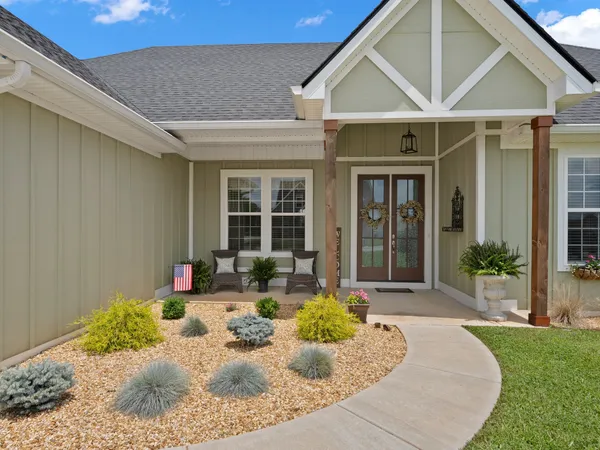 a view of a house with backyard and sitting area