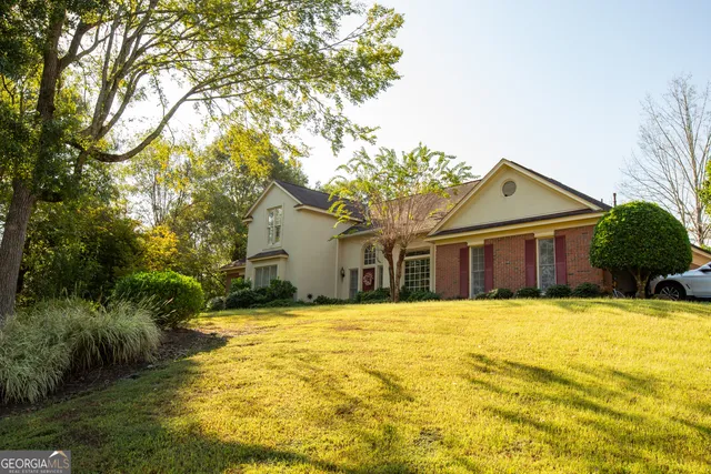 a front view of house with yard and trees around