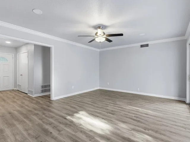 a view of empty room with wooden floor