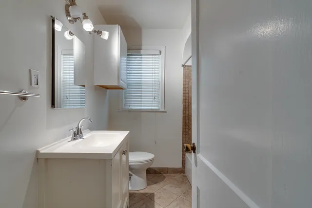 a bathroom with a toilet a sink and mirror