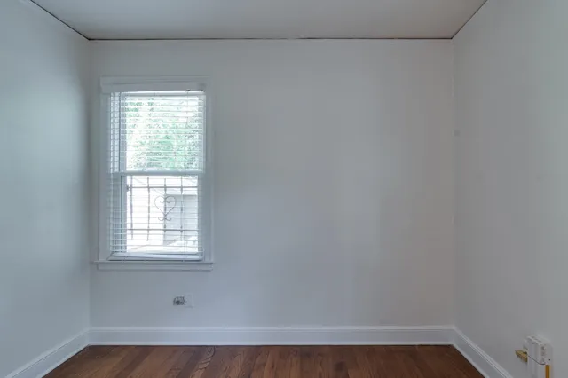 a view of a small space with wooden floor and a window