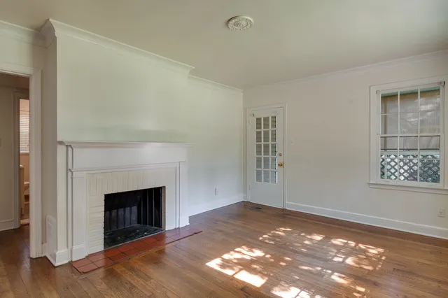 a view of a livingroom with wooden floor and a fireplace