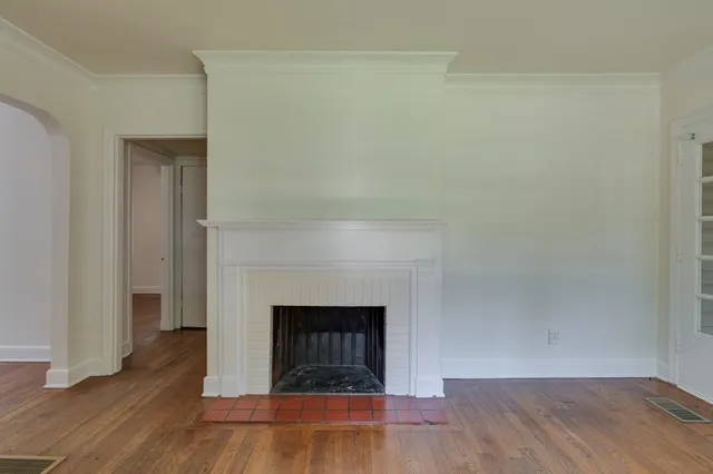 a view of a livingroom with wooden floor and a fireplace