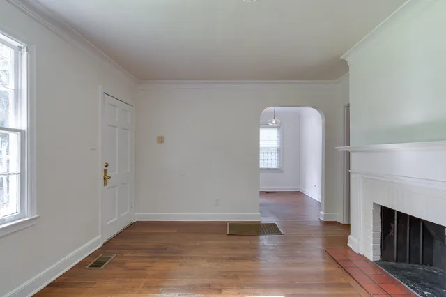 a view of empty room with wooden floor and fireplace