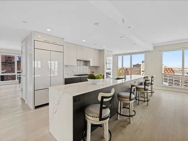 a kitchen with stainless steel appliances granite countertop a table chairs refrigerator and a sink