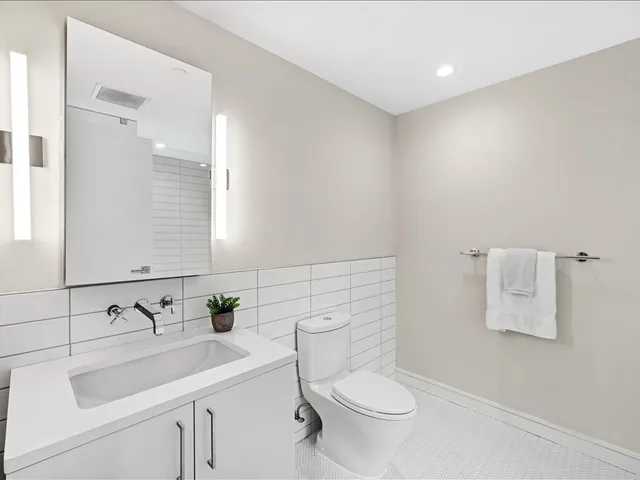 a bathroom with a toilet sink and mirror