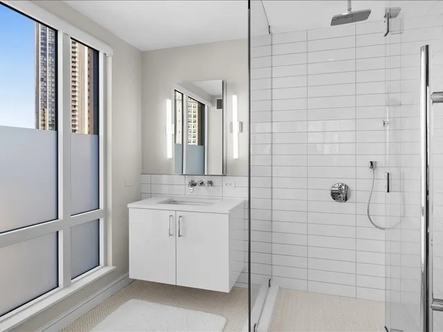 a bathroom with a double vanity sink a mirror and shower