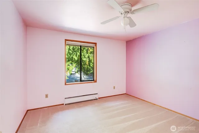 an empty room with a window and a ceiling fan