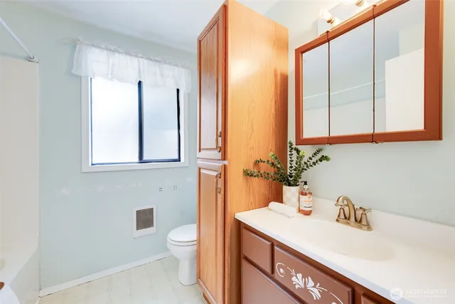 a bathroom with a sink a toilet and a large mirror