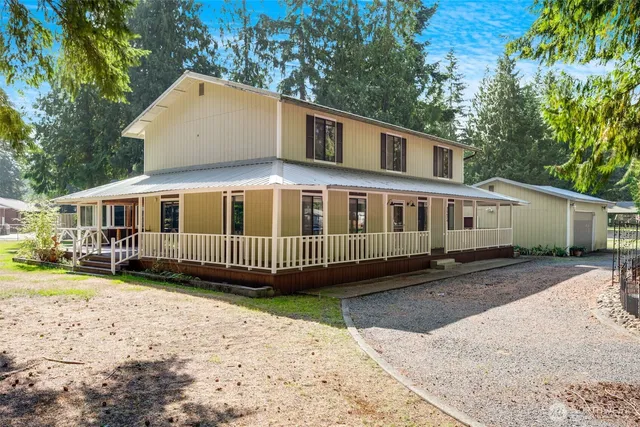 a view of a house with a yard and large trees