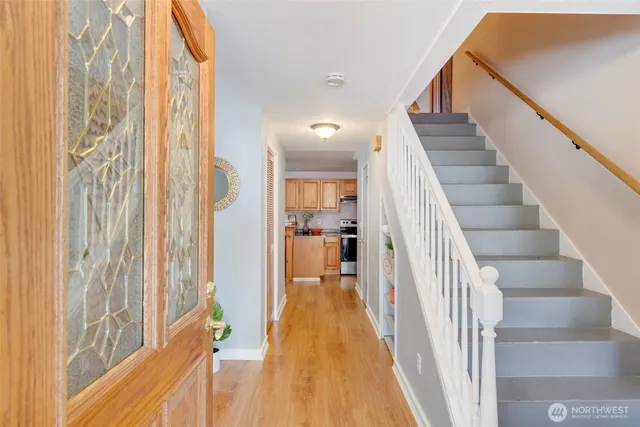 a view of a hallway with wooden floor and staircase