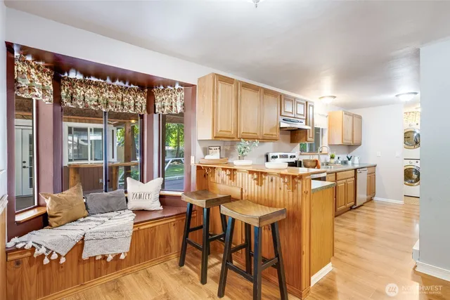 a living room with stainless steel appliances kitchen island granite countertop furniture and a large window