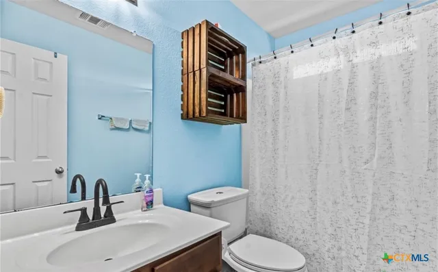 a bathroom with a sink a toilet and a mirror