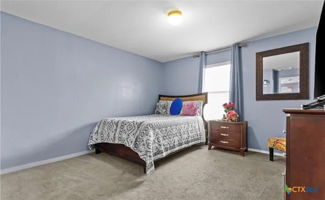 a bedroom with a bed and a lamp on desk