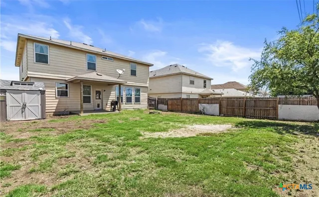 a view of a house with a yard and sitting area