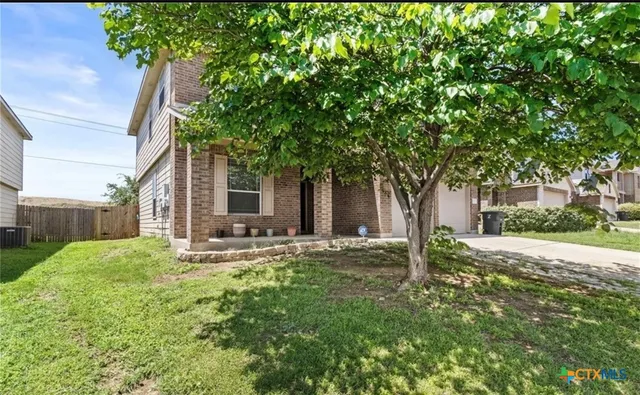 a brick house with trees in front of it