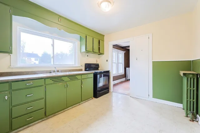 a kitchen with a sink cabinets and a large window