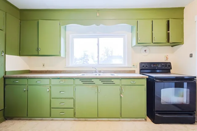 a kitchen with a sink cabinets and a large window