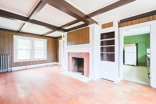 an empty room with windows and fireplace
