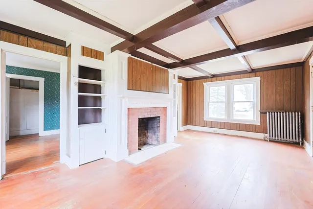 a view of an empty room with a fireplace and a window