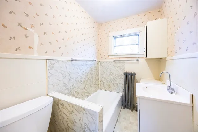 a bathroom with a sink a toilet and a window