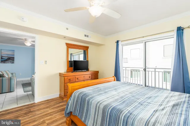 a bedroom with a bed and a flat tv screen on dresser