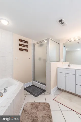 a spacious bathroom with a tub sink and a mirror