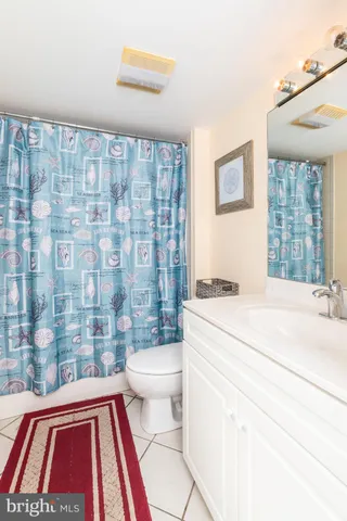 a bathroom with a sink a toilet and shower curtain