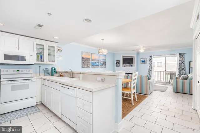 a kitchen with white cabinets and sink